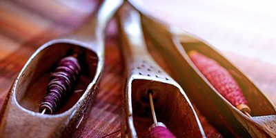 Woman working on weaving machine for weave handmade fabric. Textile weaving. Weaving using traditional hand weaving loom on cotton strands. Textile or cloth production in Thailand. Asian culture.